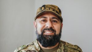 Veteran soldier man smiling at camera during army military service - Focus on face